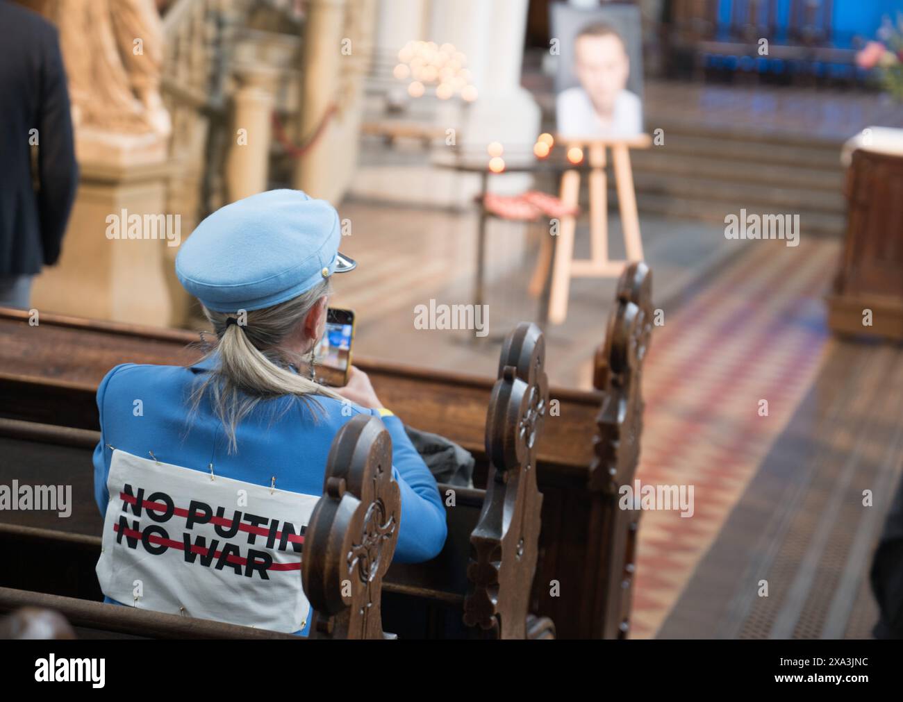 Berlino, Germania. 4 giugno 2024. Una donna indossa una giacca con l'iscrizione "No Putin No War" durante un servizio nella chiesa di Santa Maria per il politico russo dell'opposizione Alexei Navalny il giorno del suo compleanno. Navalny morì a febbraio in un campo di prigionia russo a nord del Circolo Polare Artico. I suoi sostenitori parlano di omicidio. Crediti: Sebastian Christoph Gollnow/dpa/Alamy Live News Foto Stock