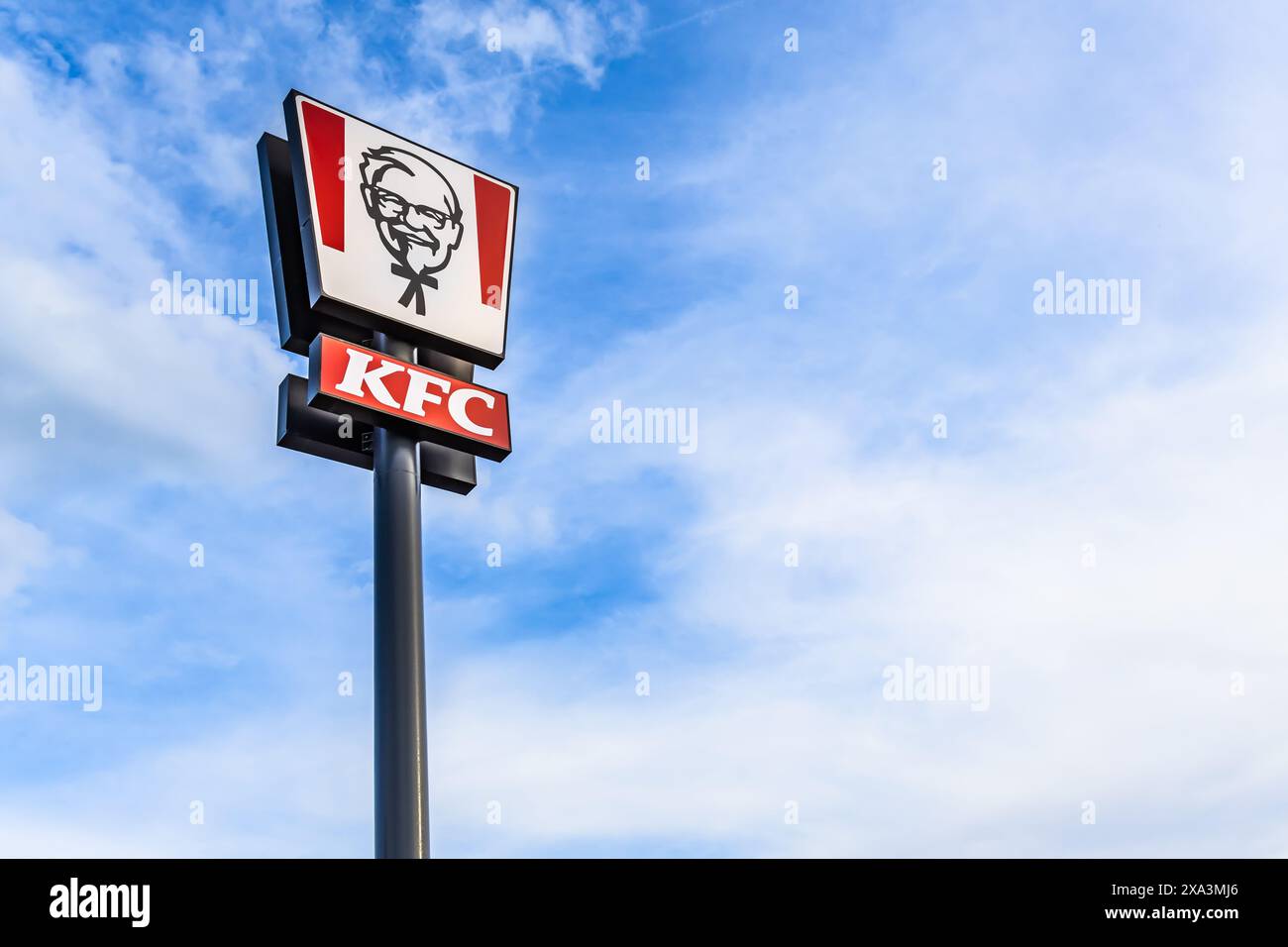 Trebic, Repubblica Ceca - 28 maggio 2024: Cartello con il logo del ristorante fast food KFC Kentucky Fried Chicken. Cartellone americano fastfood contro il cielo blu Foto Stock
