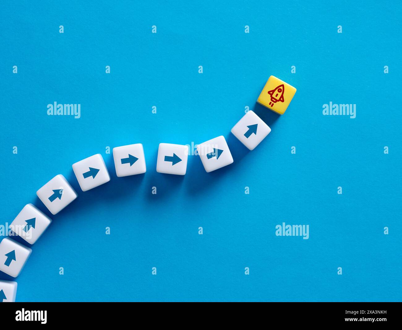 Nuovi concetti di avvio aziendale o lancio di nuovi prodotti. Simboli di razzo e freccia sui cubi. Foto Stock