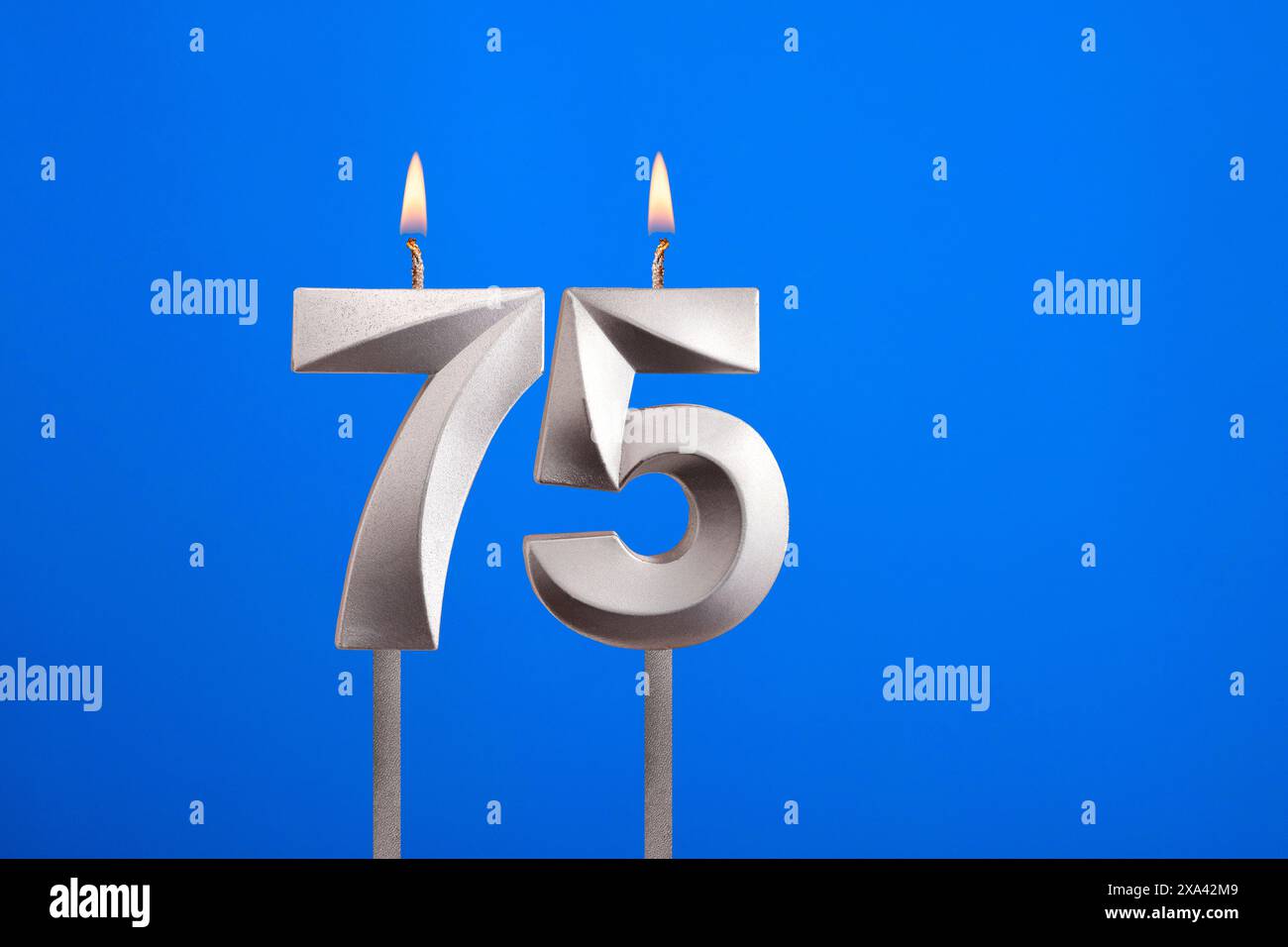 Candela di compleanno numero 75 - biglietto di auguri su sfondo blu Foto Stock