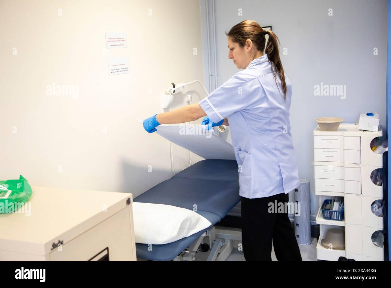 Infermiera che prepara una sala esame medico Foto Stock