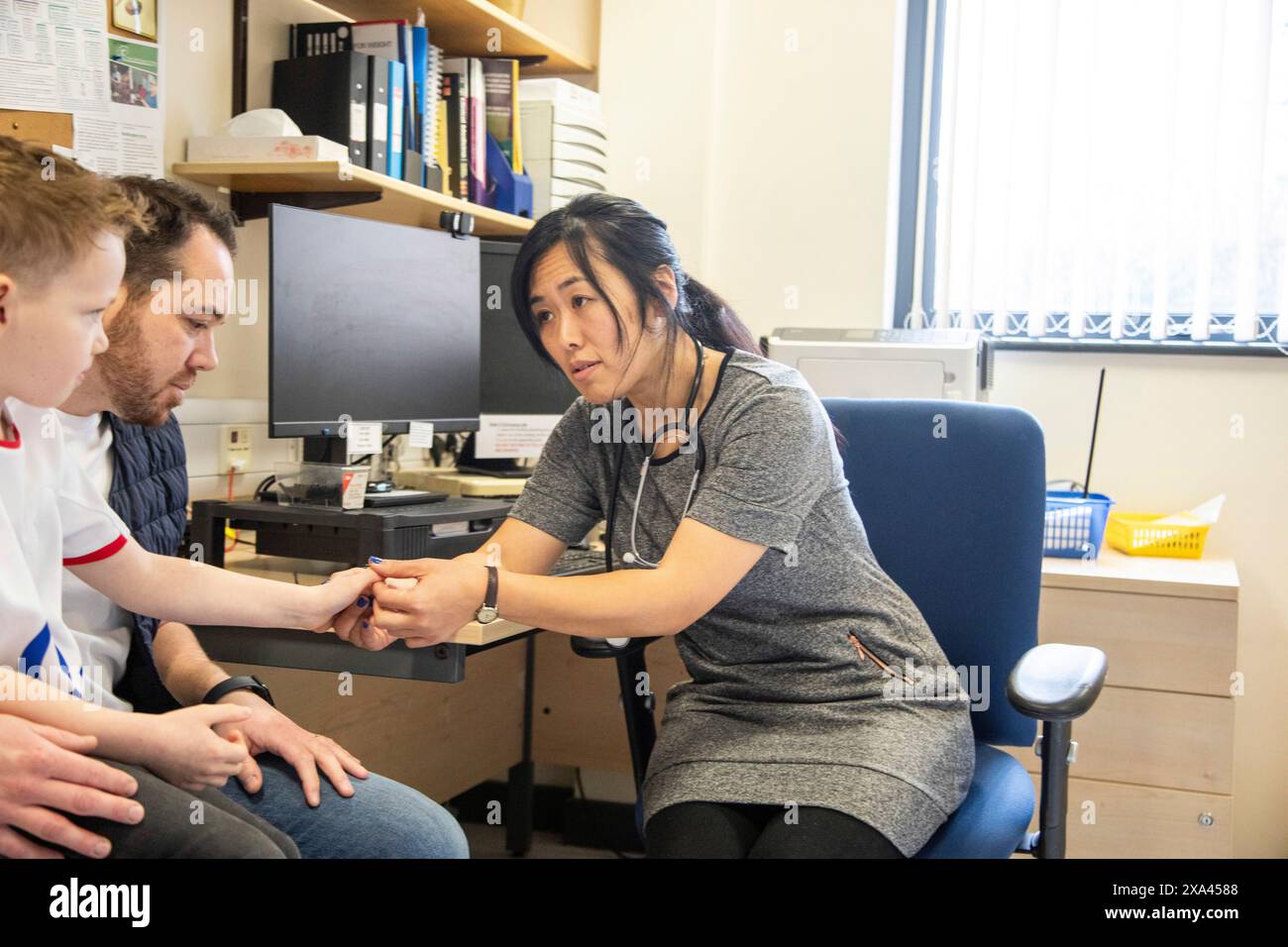 Consulenza medica con un paziente in un ufficio, padre e figlio Foto Stock