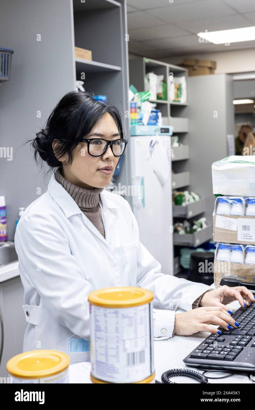 Lo scienziato lavora in un computer in un laboratorio e nell'area di spedizione di una pratica medica Foto Stock
