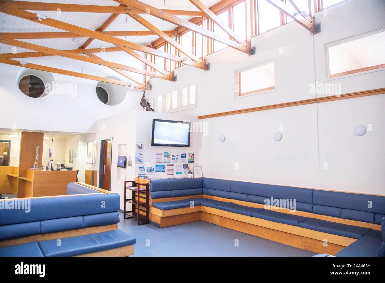Moderna area d'attesa con comodi posti a sedere e display informativi in un ospedale, Regno Unito. Foto Stock