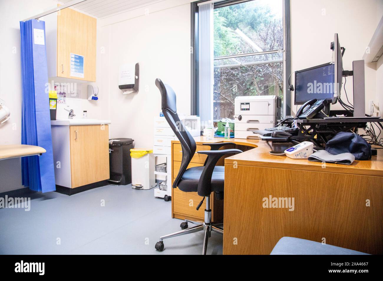 Ufficio medico con scrivania, sedia e attrezzature Foto Stock