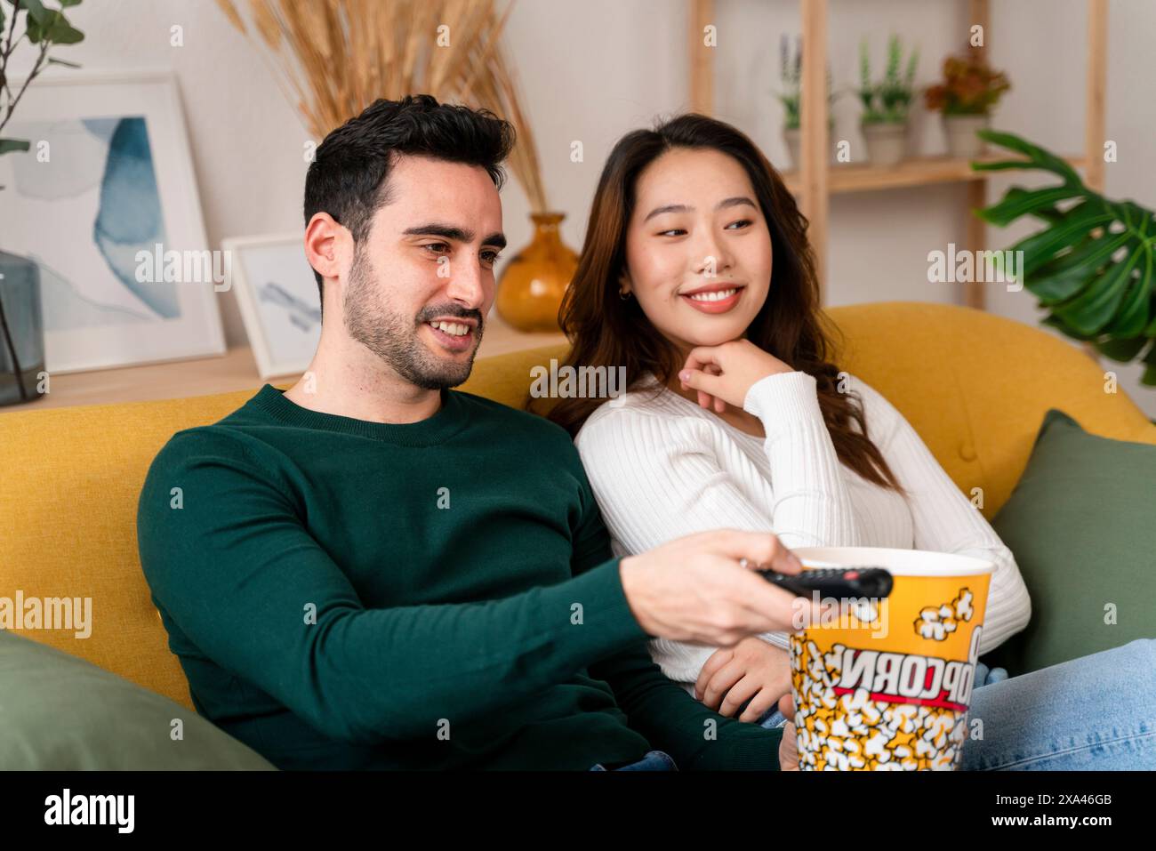 Coppia che guarda un film sul divano con popcorn Foto Stock