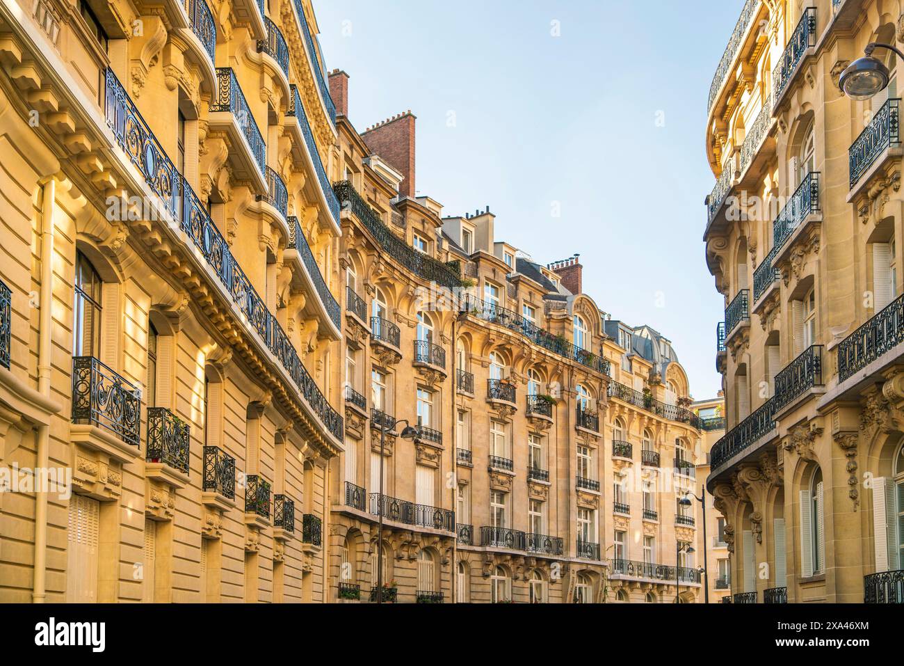 Strada parigina illuminata dal sole con architettura classica Foto Stock