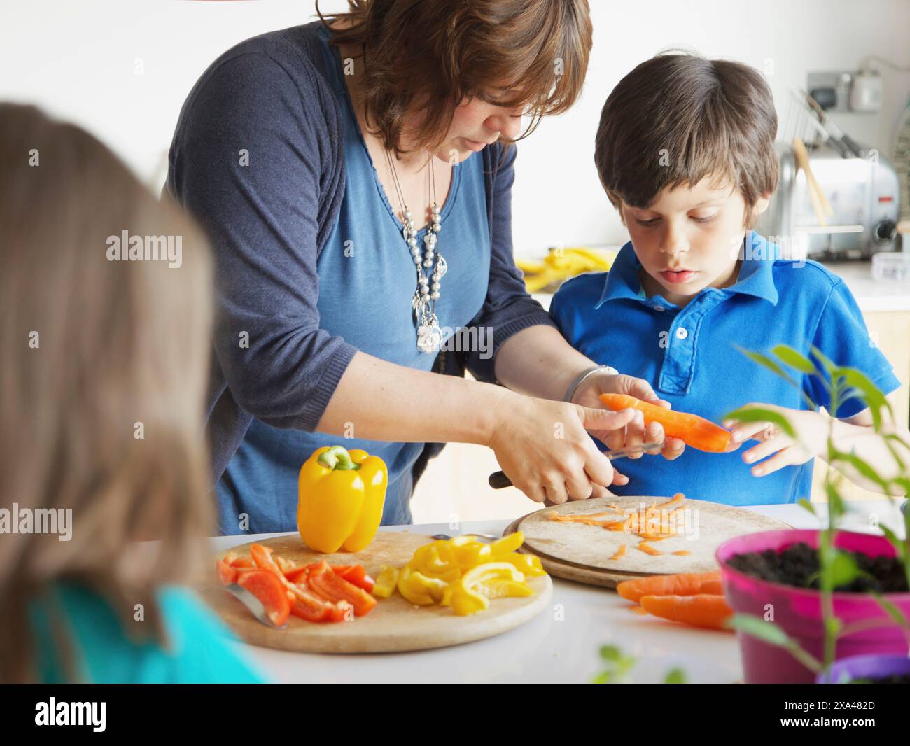 Madre e Figlio di tagliare le verdure in cucina Foto Stock