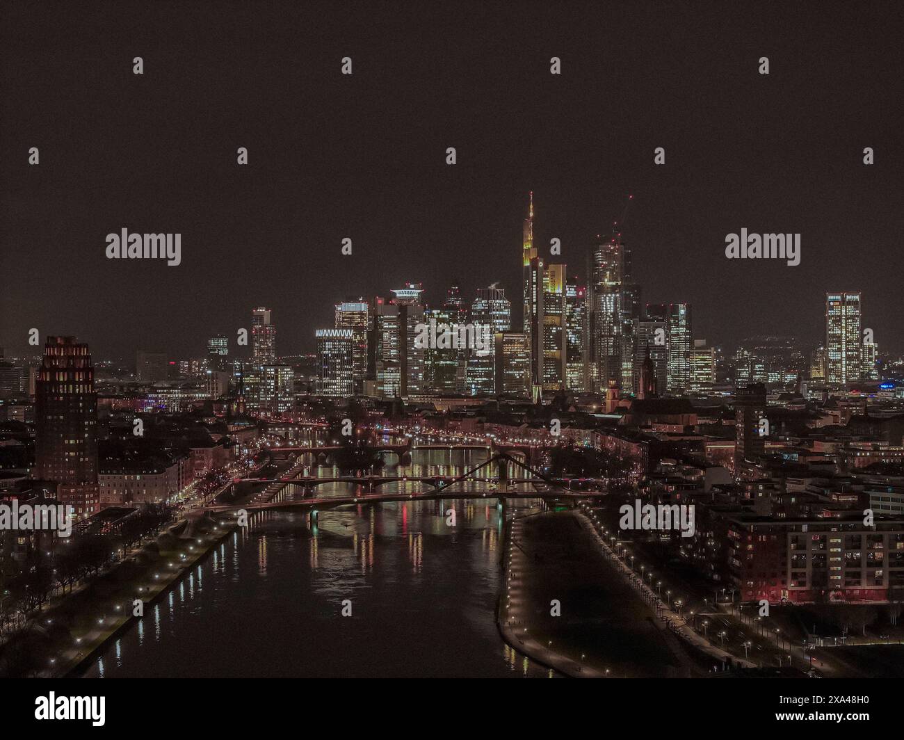 Vista aerea dei grattacieli illuminati nel paesaggio urbano lungo il fiume meno di notte, Francoforte, Germania Foto Stock