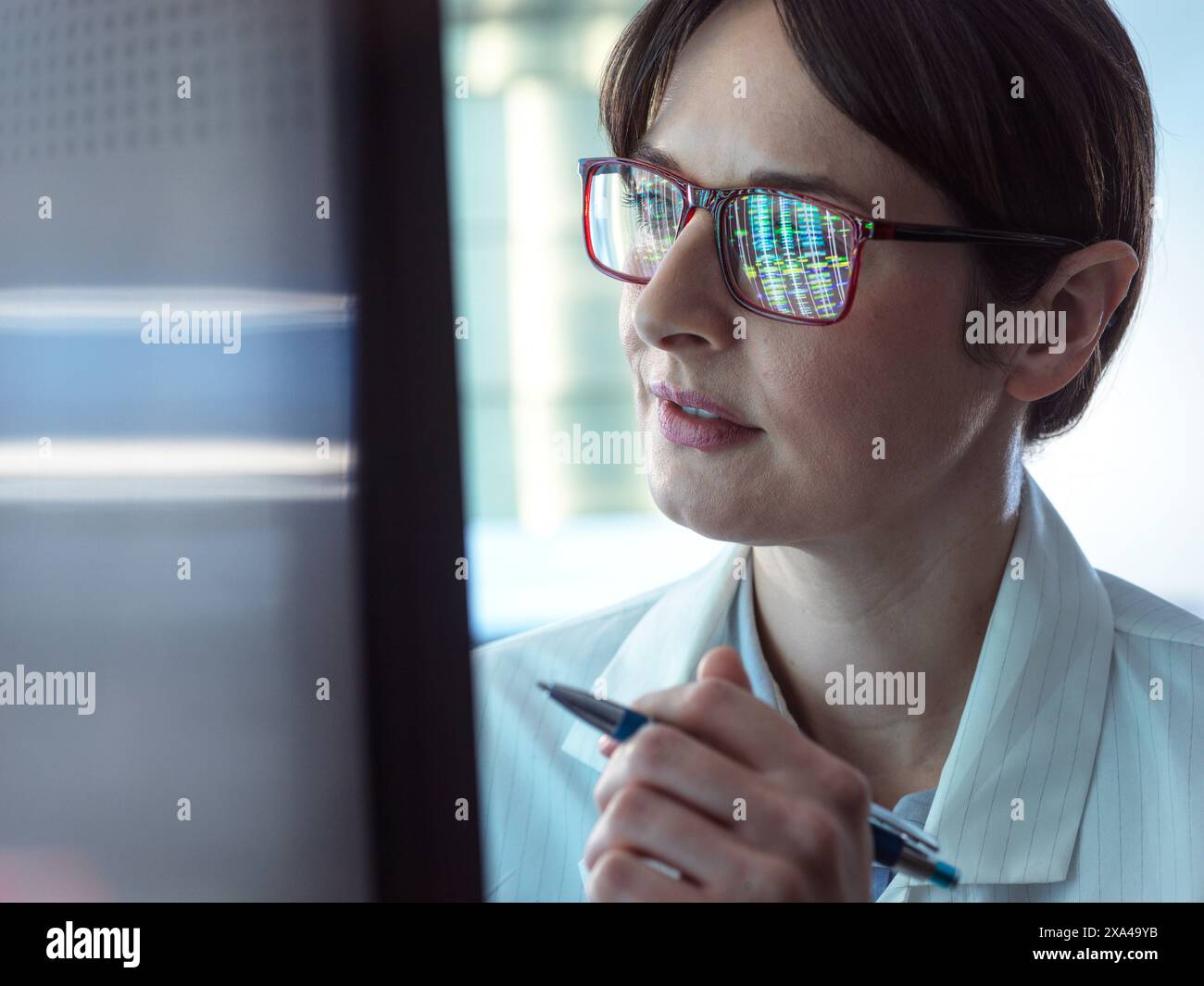 Genomica, scienziato che osserva i profili del DNA umano sullo schermo durante i test in laboratorio Foto Stock