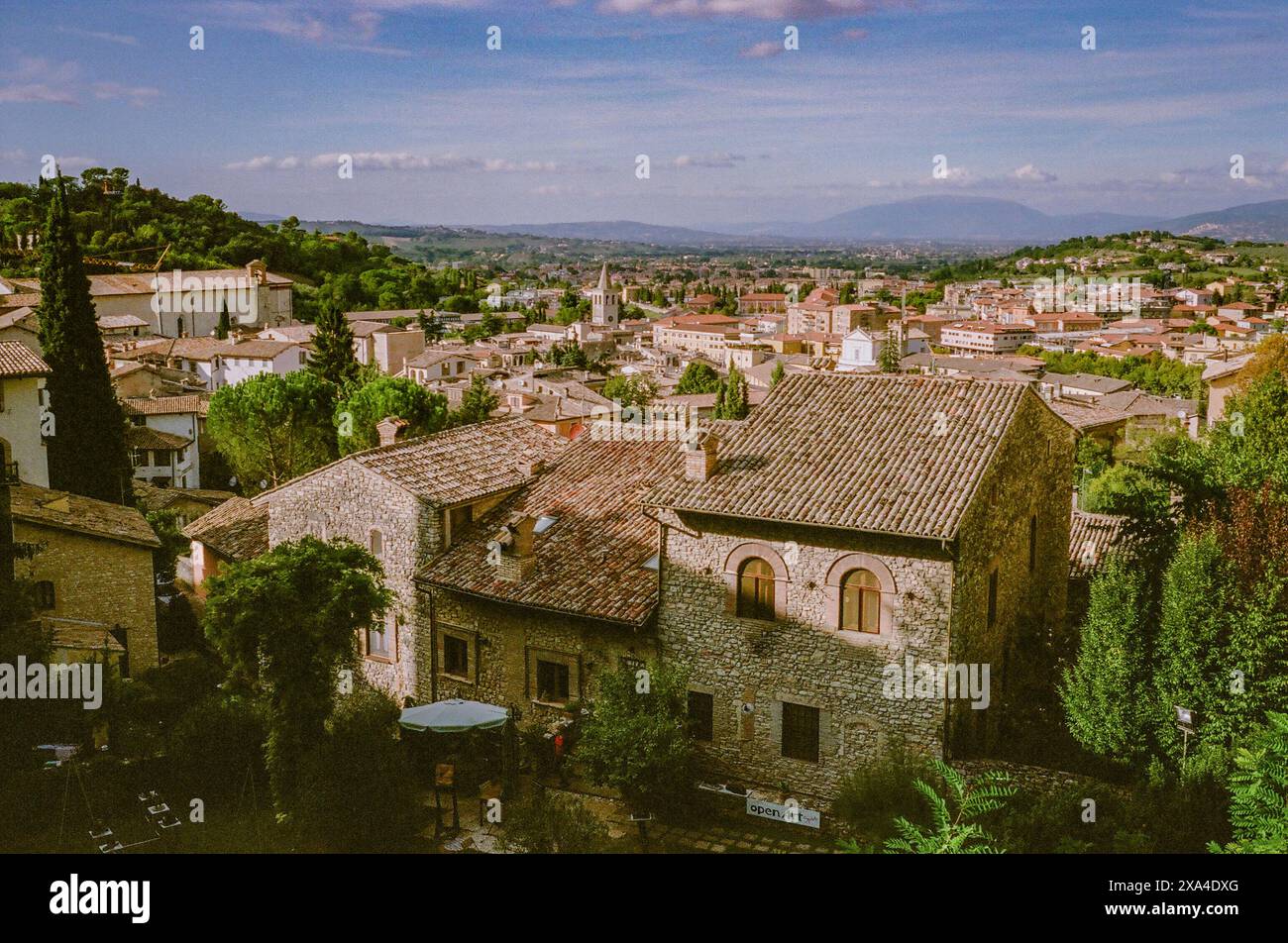 Una vista panoramica di una pittoresca città vecchia con tetti in terracotta ed edifici in pietra, sotto un cielo parzialmente nuvoloso. Foto Stock