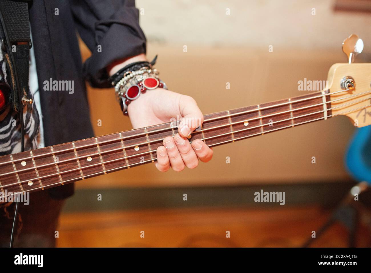 Vista ravvicinata della mano sinistra di una persona che suona la tastiera di una chitarra, con un'attenzione particolare alle dita che premono le corde. Foto Stock