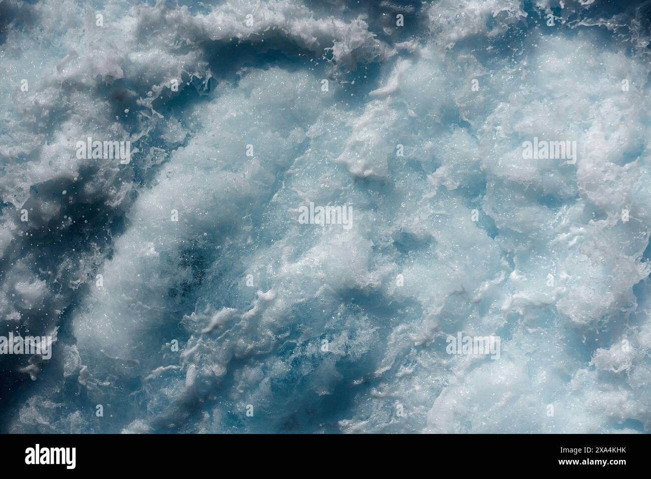 Le acque azzurre che sgorgano creano una consistenza bianca spumeggiante, che mostra i movimenti dinamici del mare. Foto Stock