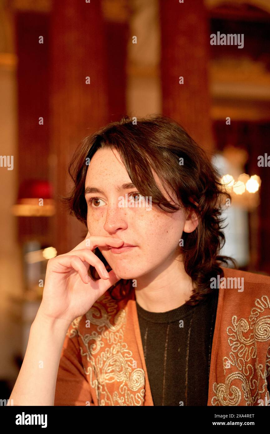 Giovane donna premurosa con la mano sul mento in un interno elegante. Foto Stock