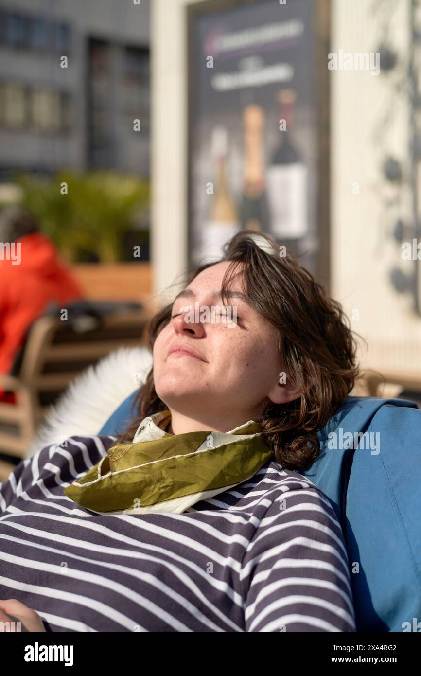 Donna che prende il sole in un ambiente all'aperto rilassato Foto Stock