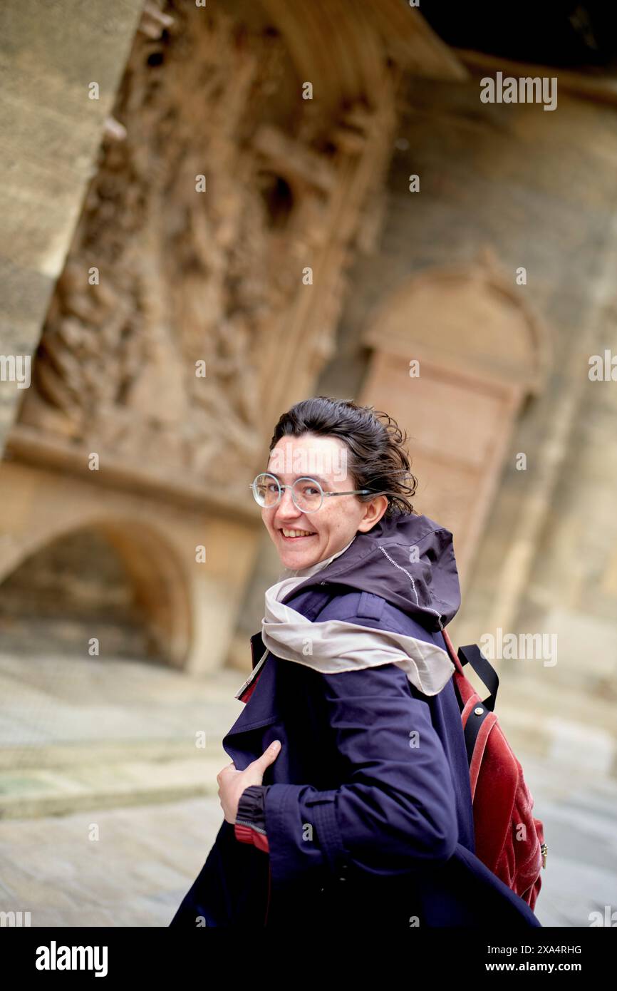Donna sorridente con occhiali in visita all'architettura storica. Foto Stock