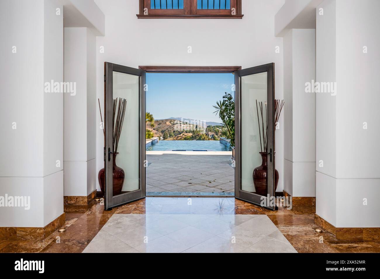 Una porta aperta in un corridoio rivela una piscina Foto Stock