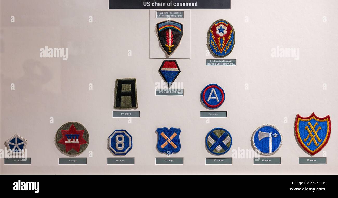 Dettaglio di varie patch di comando della catena americana su sfondo bianco al museo Battle of Normandy. Seconda guerra mondiale Foto Stock