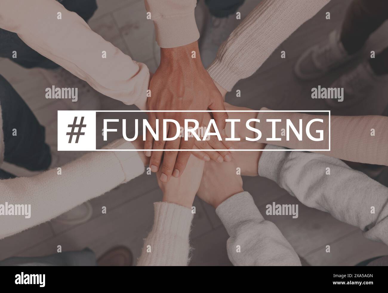 Gruppo di persone che uniscono le mani in ambienti interni, vista dall'alto. Hashtag Fundraising su di loro Foto Stock