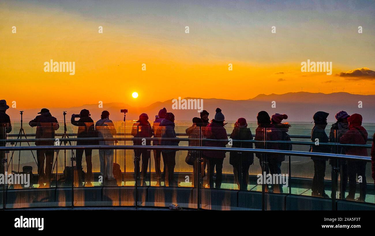 Un gruppo di persone sulla passerella di vetro ammirerà il tramonto a Damakan, Kunming City, Yunnan, Cina Foto Stock