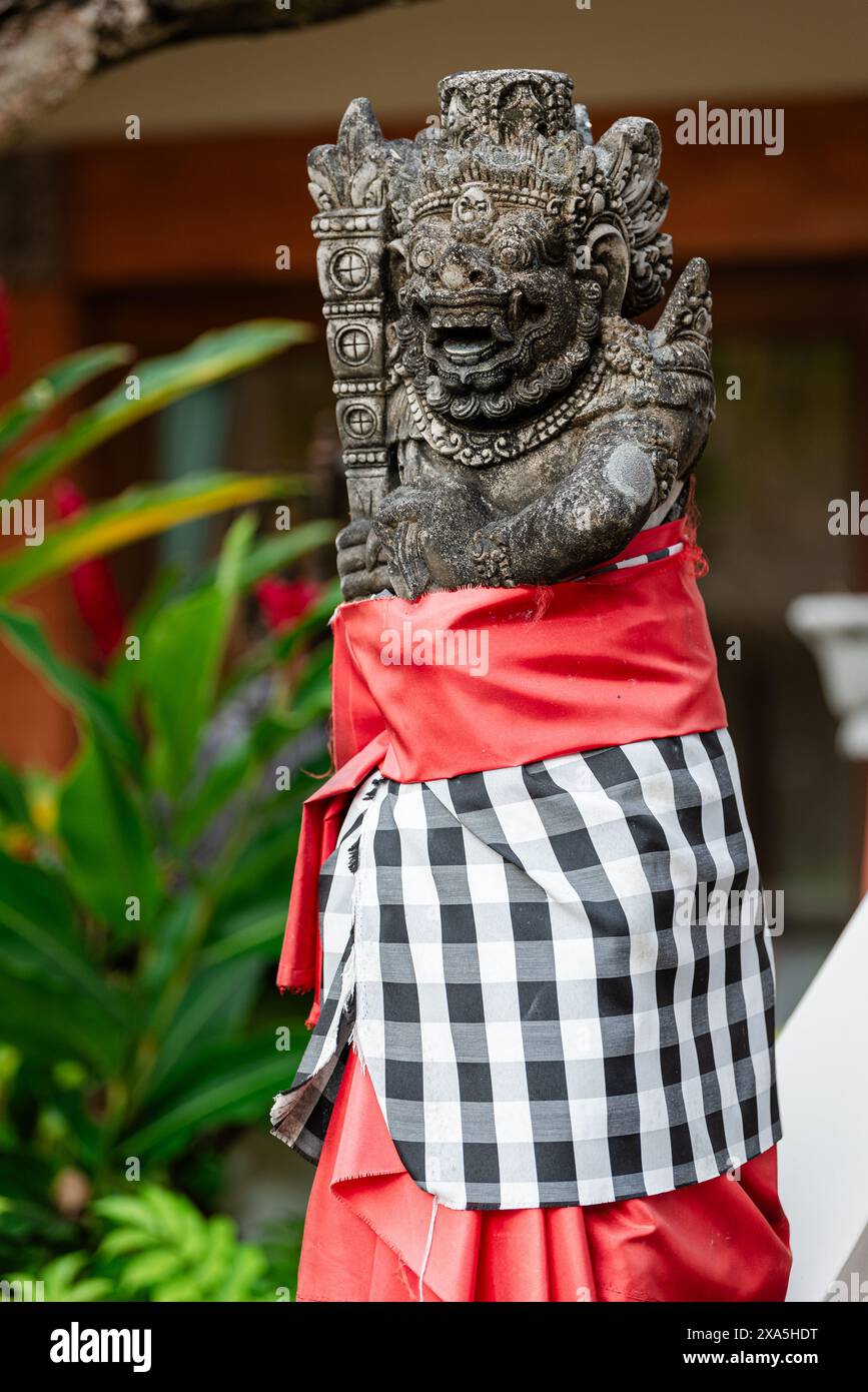 Una tradizionale statua di guardia demoniaca scolpita in pietra nell'isola di Bali. Foto Stock