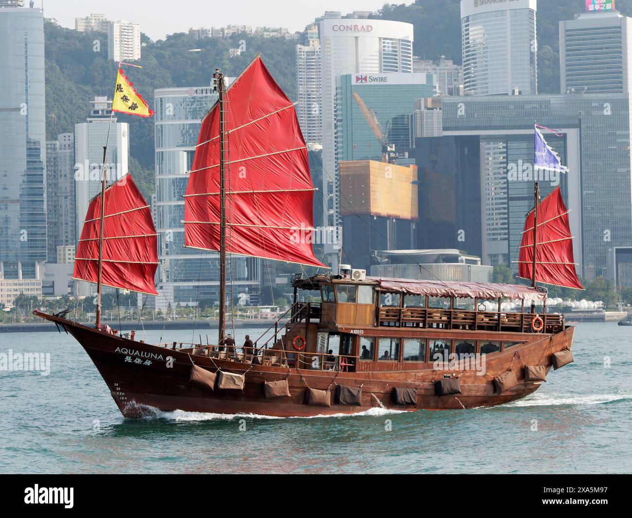 Vista di un tour in barca del porto di Hong Kong con vele rosse Foto Stock