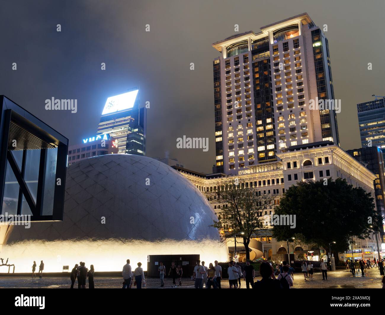 Una vista notturna del Museo spaziale di Hong Kong con il grandioso Peninsula Hotel sullo sfondo Foto Stock