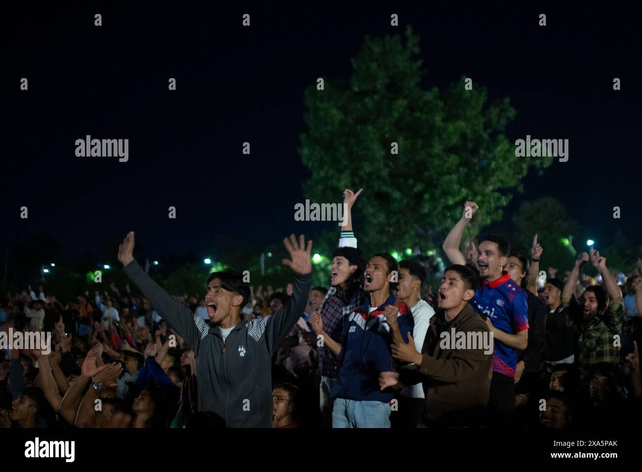 Nepal. 4 giugno 2024. Il 4 giugno 2024, a Kathmandu, Nepal. I tifosi nepalesi fanno il tifo mentre si riuniscono per guardare la proiezione dal vivo sul campo aperto della capitale durante la partita di cricket di apertura della Coppa del mondo T-20 tra Nepal e Neatherlands. (Foto di Abhishek Maharjan/Sipa USA) credito: SIPA USA/Alamy Live News Foto Stock