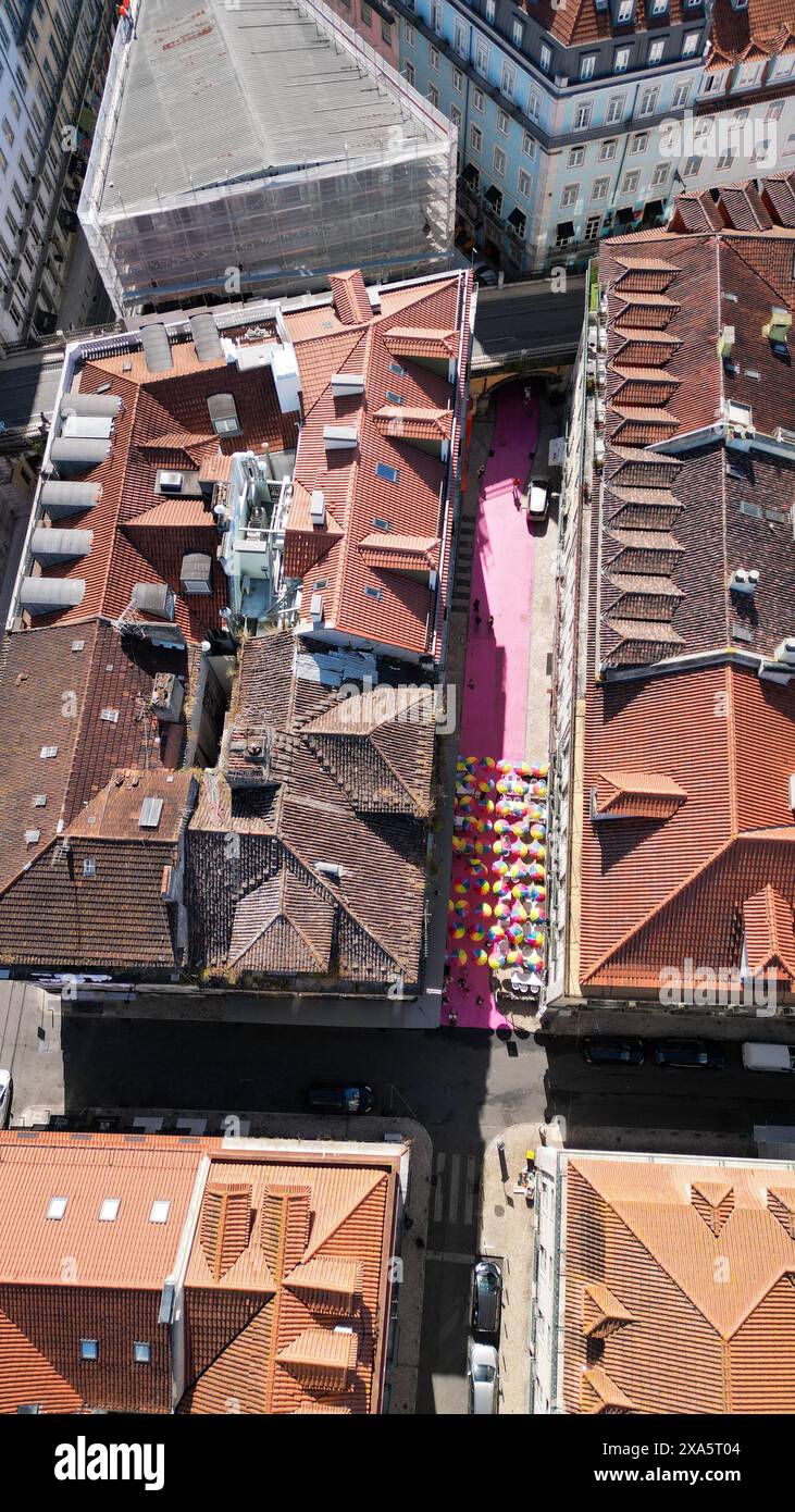Da sopra la strada rosa con ombrelli colorati appesi. E' uno dei posti piu' popolari per godersi la vita notturna di Lisbona, situato a Cais do Sodre. Foto Stock