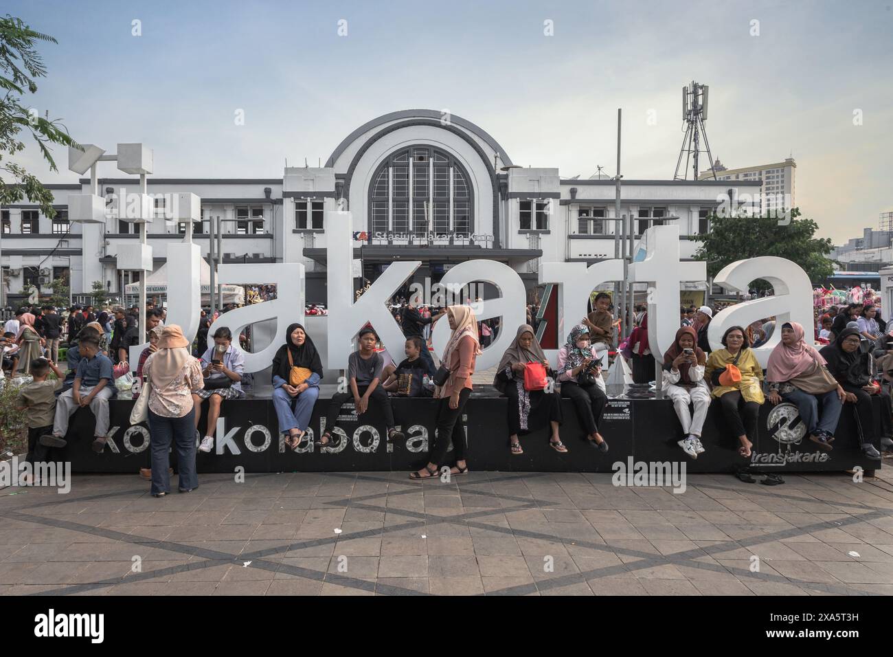 Un gruppo eterogeneo di persone sedute su una strada Foto Stock