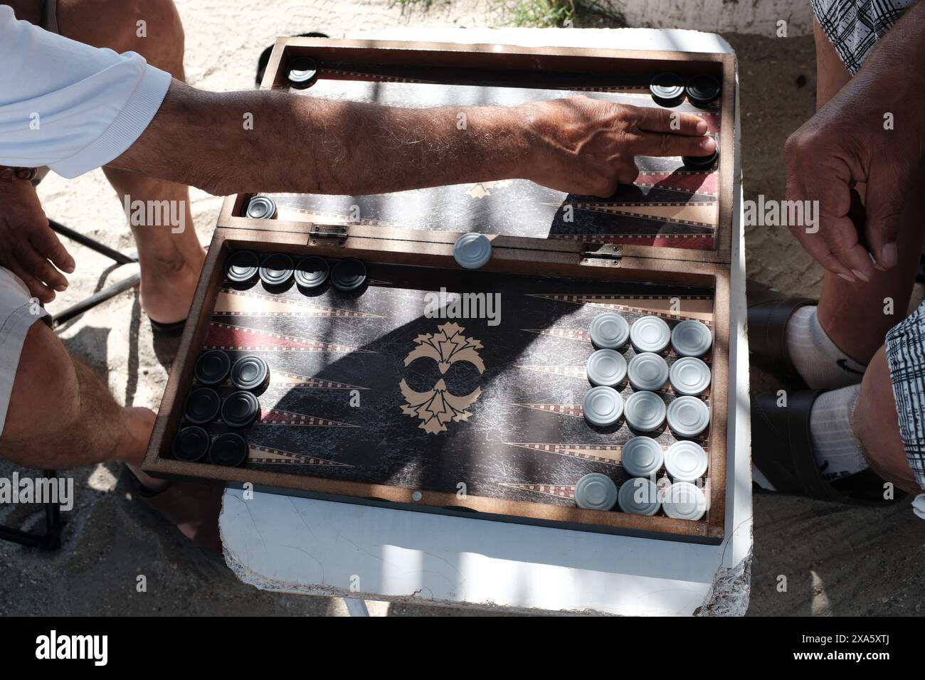 Un gruppo di persone che si impegnano in un gioco da tavolo con le tazze Foto Stock