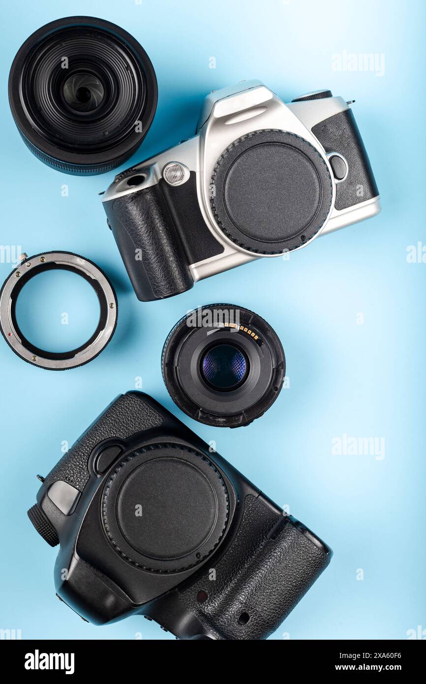 Le varie fotocamere, fotocamere digitali e componenti dell'obiettivo su uno sfondo blu. Foto Stock