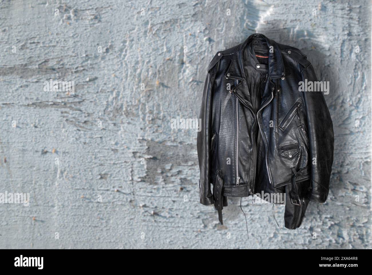 Eleganti giacche in pelle appese a una parete intemprata Foto Stock