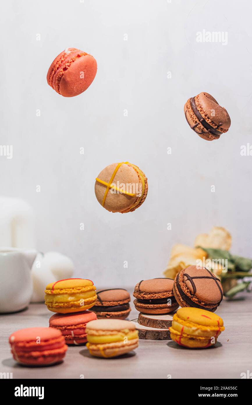 Biscotti assortiti su un tavolo, con macaron a mezz'aria Foto Stock