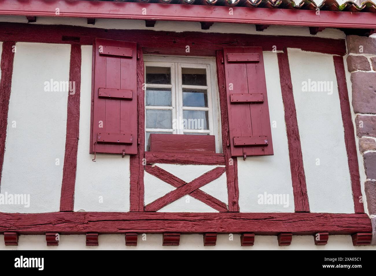 Vecchia piccola finestra con persiane rosse in legno Foto Stock