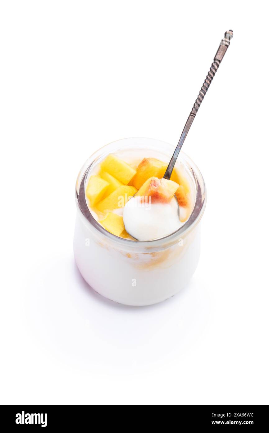 Yogurt fatto in casa in vaso con frutta fresca di pesca isolata su bianco Foto Stock
