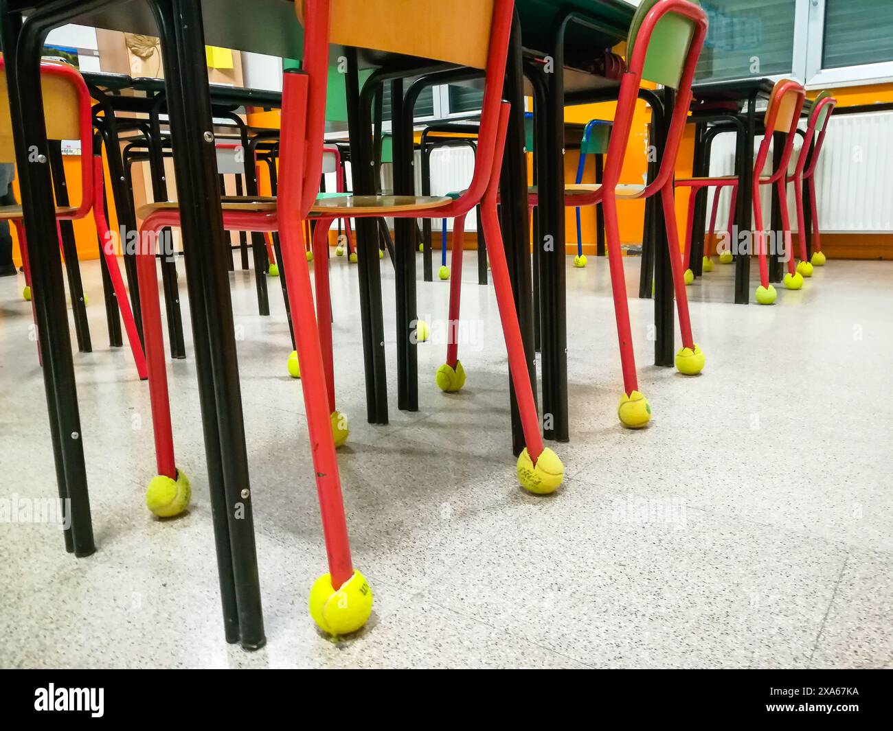 Sedie in aula in una fila con palla da tennis come paraurti Foto Stock