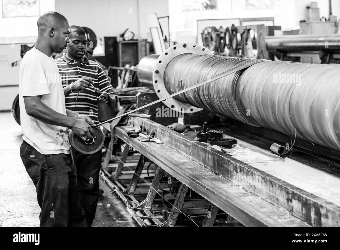 Gli oratori in fabbrica che esaminano macchinari insieme a Johannesburg, Sudafrica Foto Stock