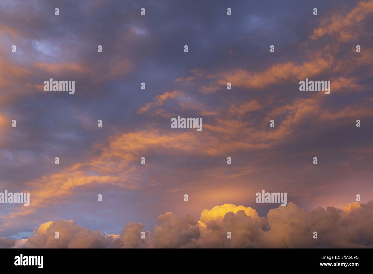 foto di un cielo serale al tramonto con cullo dorato e viola e nuvole perisferiche Foto Stock