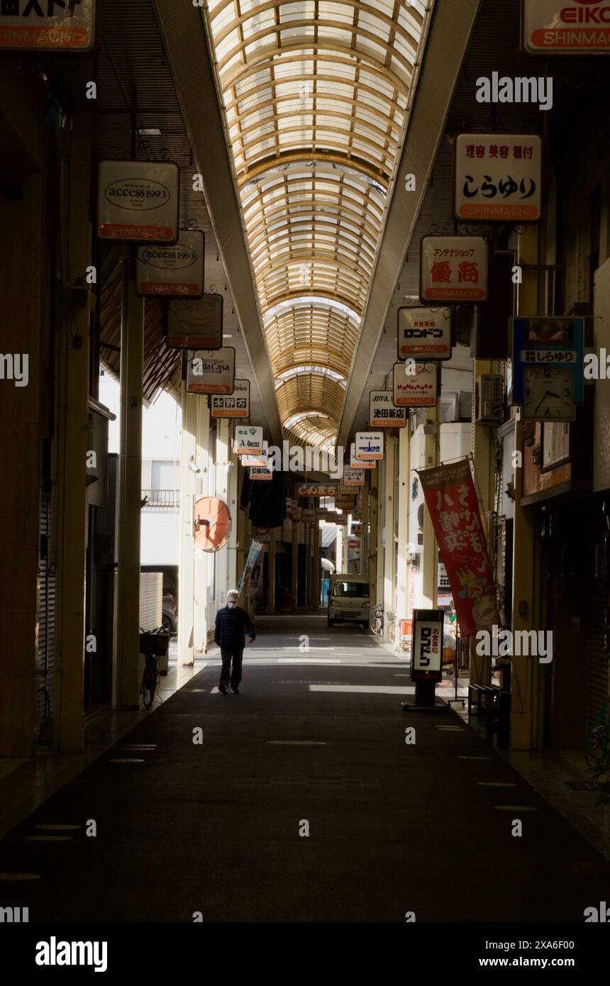 Un vecchio centro commerciale coperto a Ehime, in Giappone, con un vecchio che passeggia accanto Foto Stock
