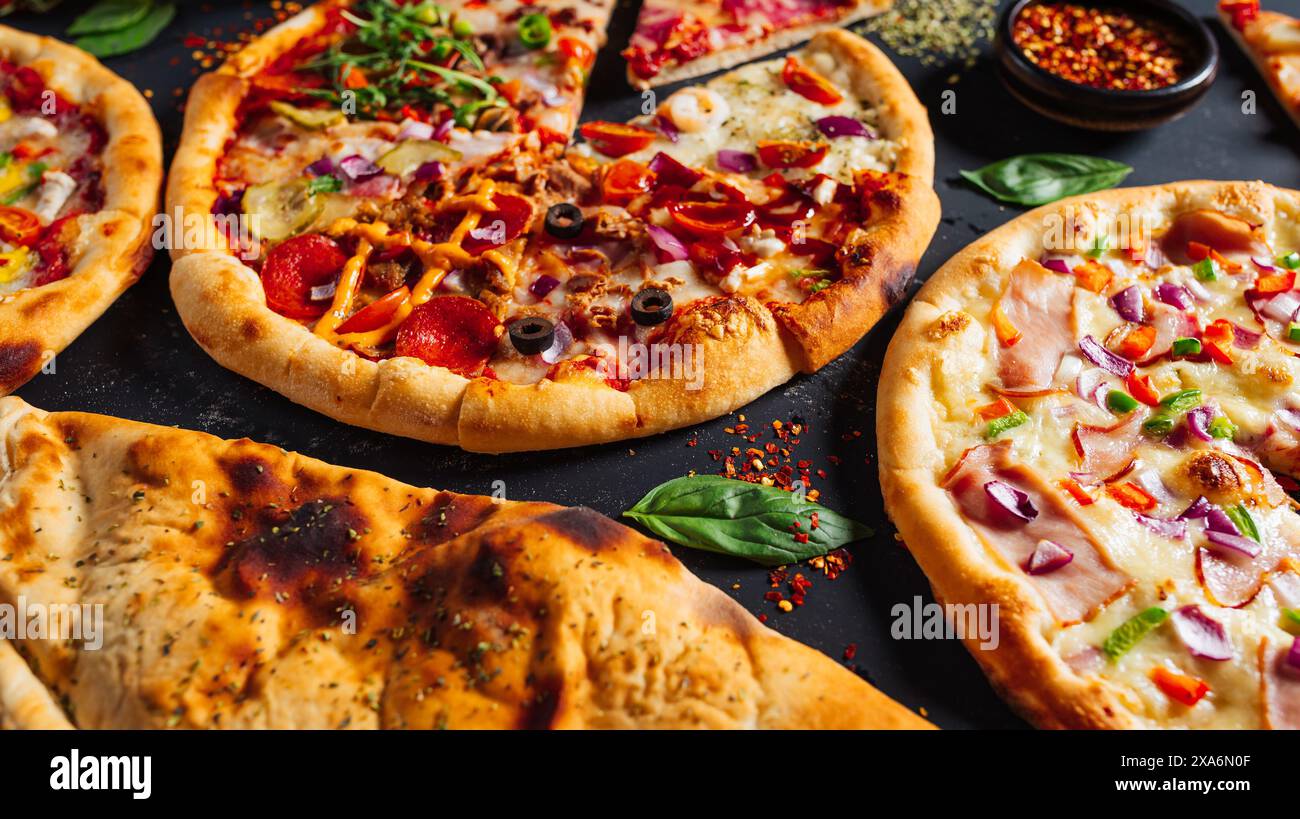 Pizze assortite con vari condimenti su un tavolo Foto Stock