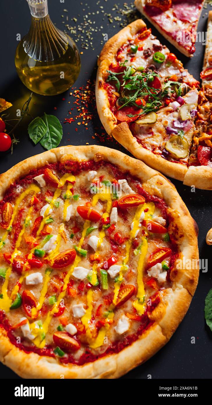 Due pizze con farciture assortite su un tavolo Foto Stock