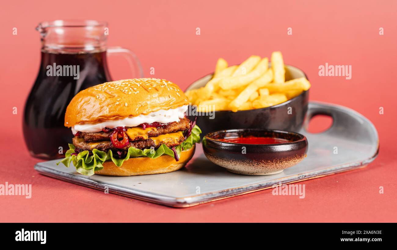 Un delizioso hamburger e patatine fritte con salsa su un piatto Foto Stock