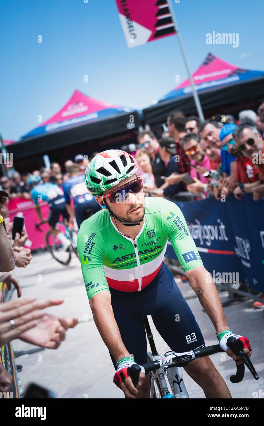 Ciclista maschile che percorre una strada insieme ad altri ciclisti Foto Stock