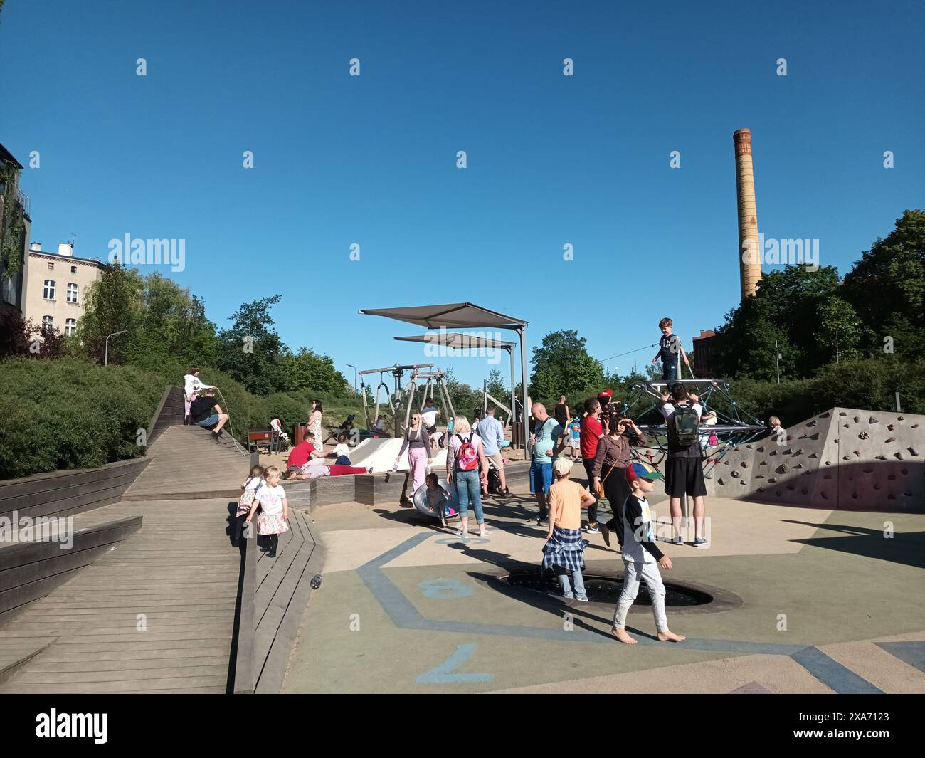 Un gruppo di persone che si riuniscono al parco di pattinaggio accanto agli alberi Foto Stock