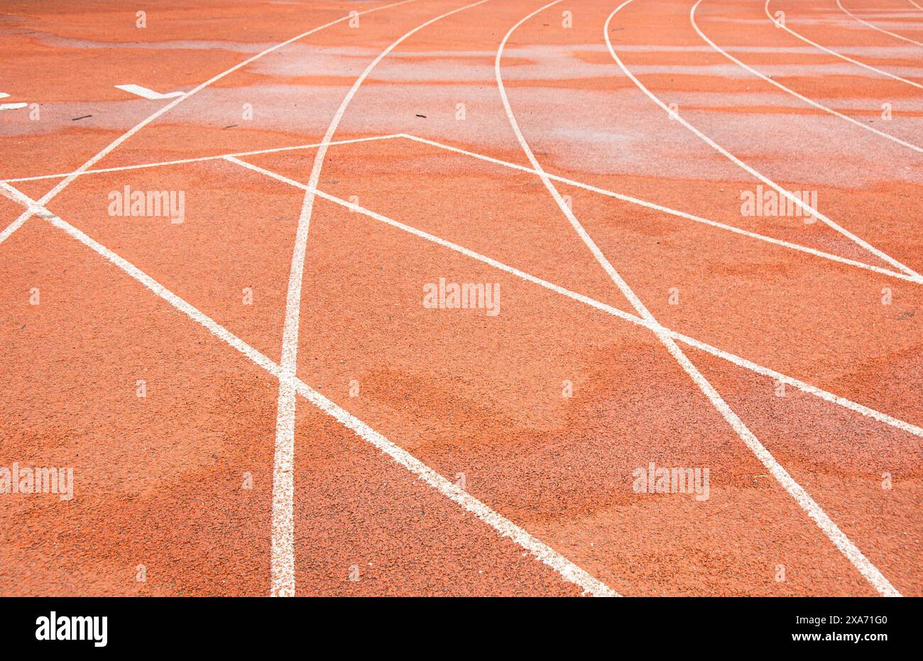 La pista rossa brillante di un'università di Wuhan. La curva bianca si interseca con la linea retta. Foto Stock