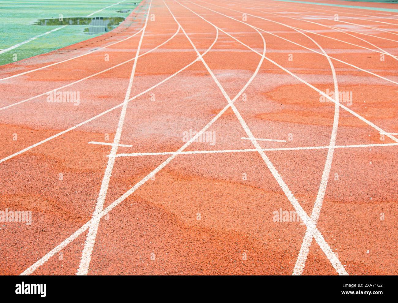 La pista rossa brillante di un'università di Wuhan. La curva bianca si interseca con la linea retta. Foto Stock
