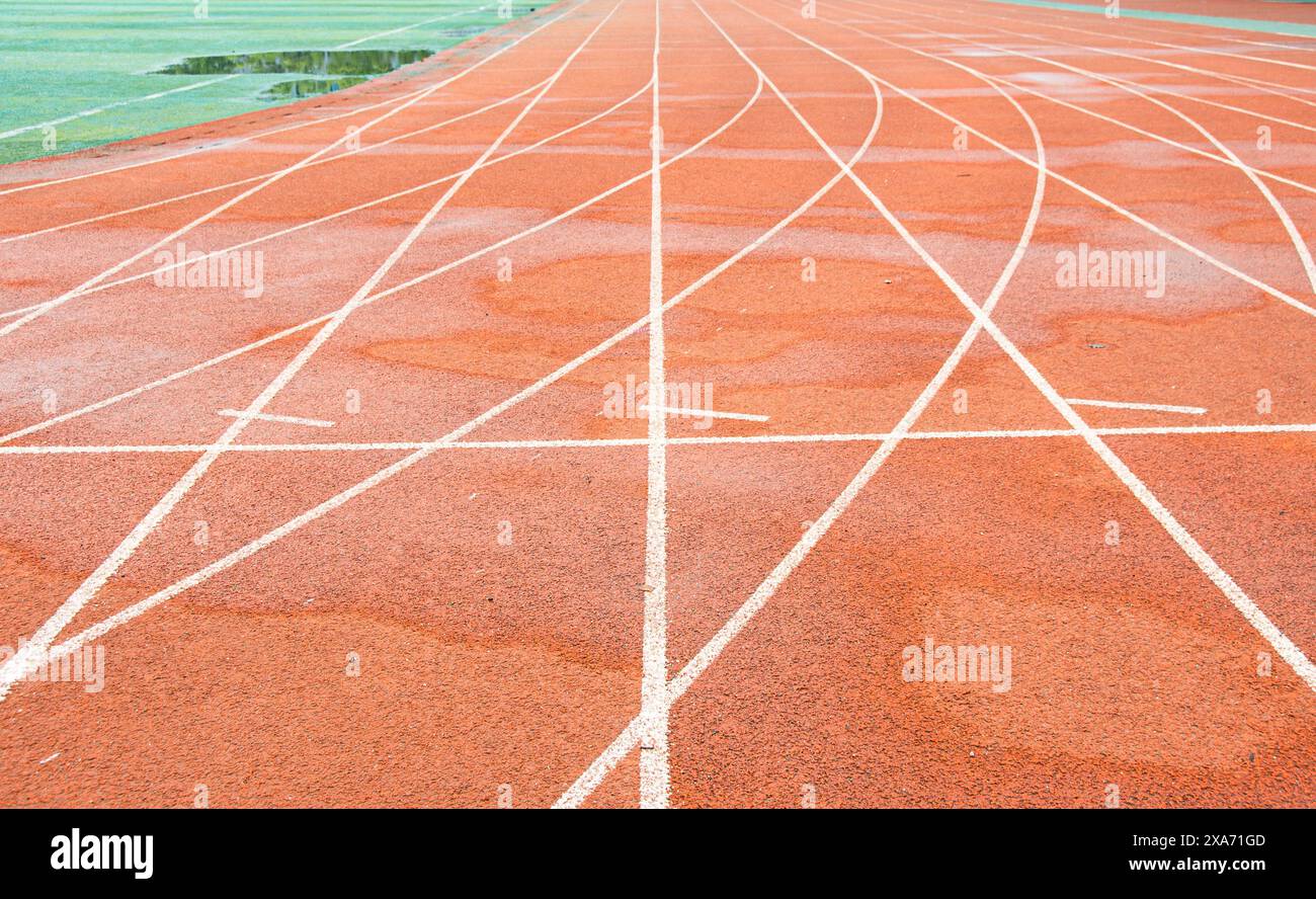 La pista rossa brillante di un'università di Wuhan. La curva bianca si interseca con la linea retta. Foto Stock