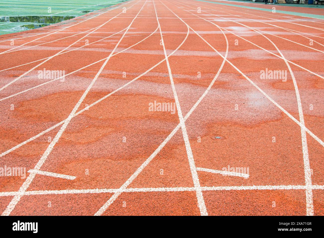La pista rossa brillante di un'università di Wuhan. La curva bianca si interseca con la linea retta. Foto Stock