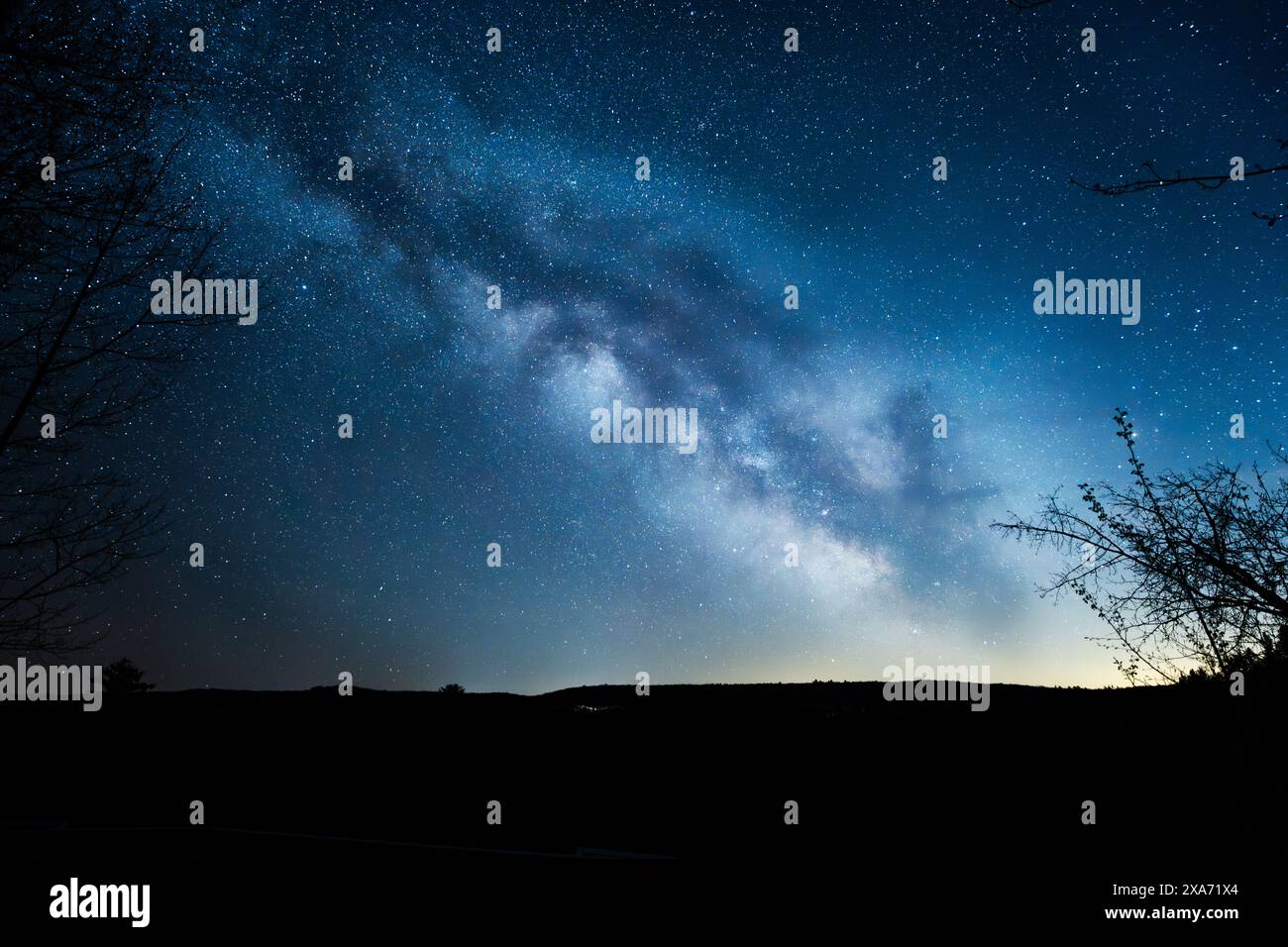 Una vista della via Lattea dal Big Bend Lookout di Arrowhead Park, a metà primavera con un cielo blu e arancione e sfumature di viola all'interno della nebulosa Foto Stock
